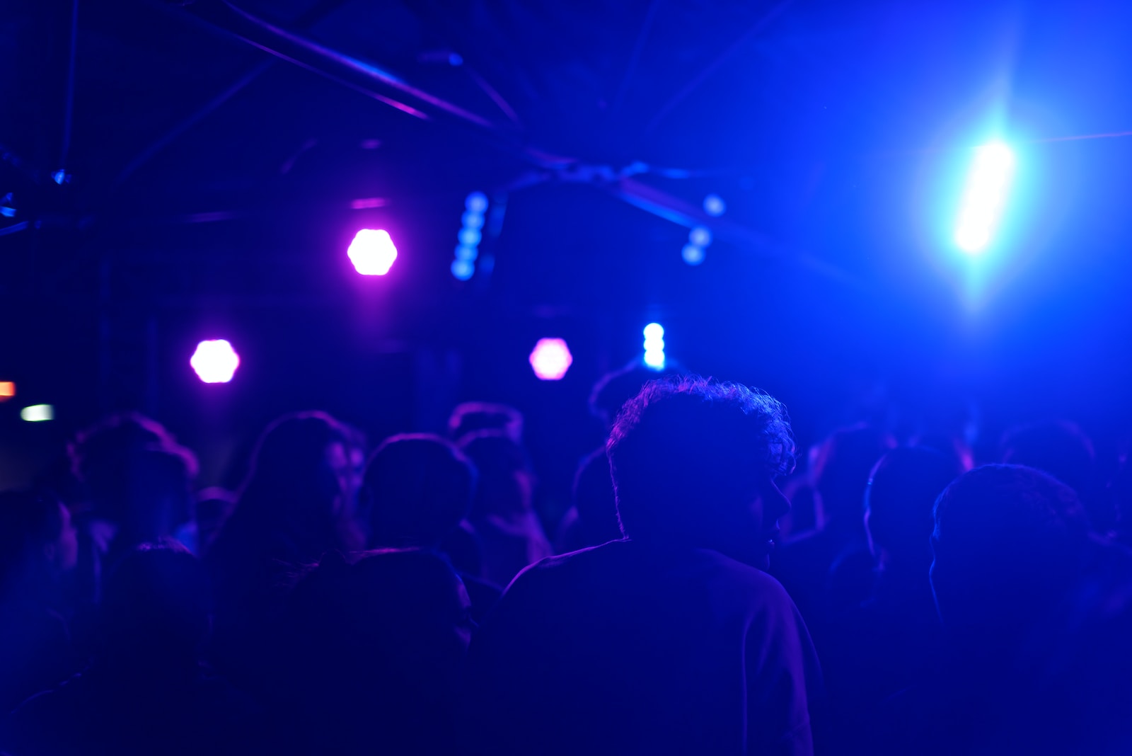 a crowd of people in a dark room with bright lights