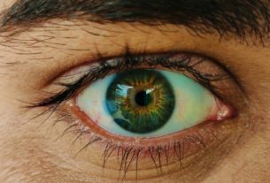 A macro view of a human eye with a green and brown iris